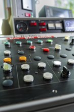 Close-up of a control panel with various round buttons and switches, Hermann Hesse railway track