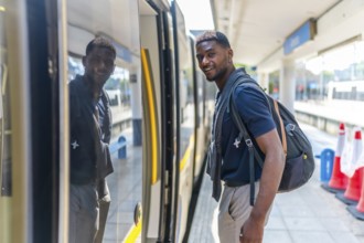 Side view photo of a confident young African casual businessman boarding an intercity train