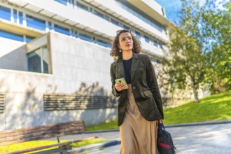 Low angle view photo of an Arab young freelancer using mobile walking along the city