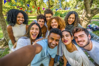 Multi-ethnic happy group of friends taking selfie celebrating party in a urban park