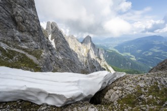 Residual snow in a saddle in spring, rocky mountain landscape, ascent to the summit of the