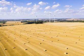 Straw bales on a harvested grain field from above, wind turbines in the background, Nossen, Saxony,