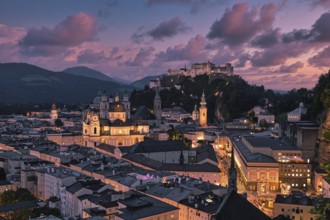 Salzburg's illuminated night view with the fortress and Alpine panorama, captured in the soft glow