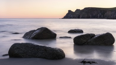 Coastal landscape. Rocks in the sea. In the evening after sunset. Long exposure. Nanjizal Bay, St
