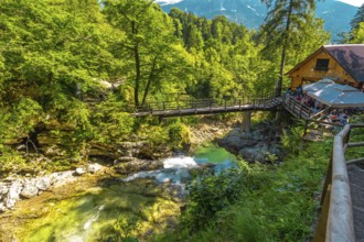 Wooden bridge and restaurant above radovna river flowing through vintgar gorge near bled, slovenia,