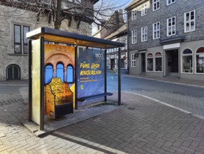 Bus stop in the old town centre with golden Kaiserstuhl and the words Fühl Dich Kaiserlich, Goslar,