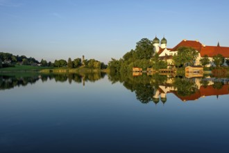 Romanesque Benedictine abbey Seeon monastery, monastery church St. Lambert with reflection in the