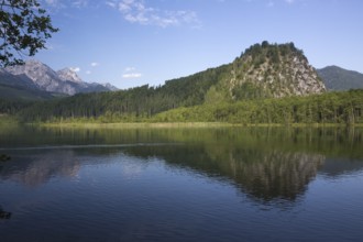 Lake Almsee in summer with totally smooth surface showing reflexion of the mountain Ameisstein