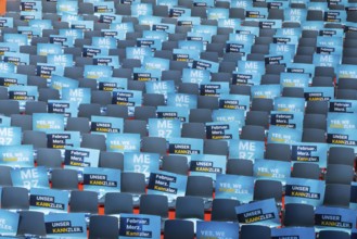 Assembly hall, deserted with many empty chairs and posters with the inscription UNSER KANNZLER.