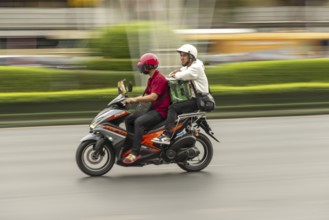 Two men on a moving motorbike, Radchadamnoen Klang Road, Phra Nakhon, Bangkok, Thailand, Asia
