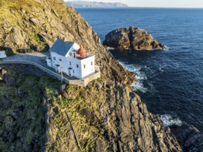 Aerial view of Krakenes Fyr lighthouse, lighthouse located on steep cliff, norwegian coast north of