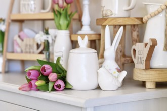 Cute seasonal Easter decor with small canister with bunny ears, bird and pink tulip flower boquet