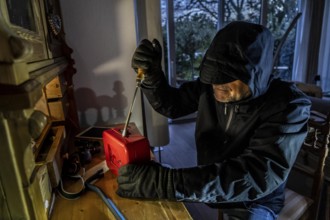 Symbolic image of a burglary, perpetrator has broken into a flat from the garden side and is