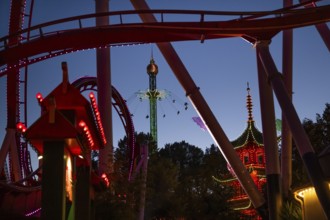 Roller coaster, chain carousel and pagoda at night, Tivoli Amusement and Recreation Park,
