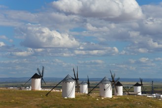 Panoramic view of several white windmills in a vast landscape under a slightly cloudy sky, Campo de