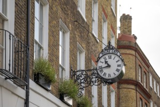 Classic clock with original lettering You're late on a building facade, Doughty Street, Holborn,