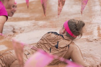 Group of participants in a muddy outdoor obstacle course
