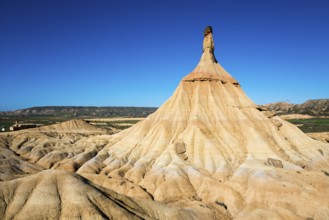 A striking rock formation in a desert landscape under a clear blue sky, Castildetierra, Bardenas