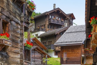 Old wooden houses with flower boxes in front of windows and balconies in the historic village