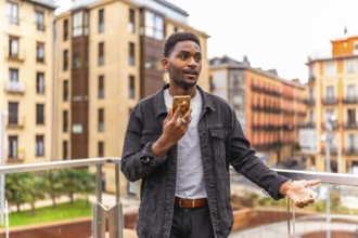 African man sending a voice message using mobile phone in the city