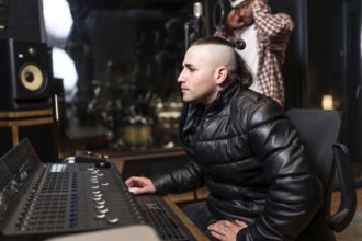 Sound engineer mixing a pop, rap or trap song using a digital audio workstation and soundboard in a