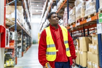 Latin male warehouse worker carrying scan to scan cargo