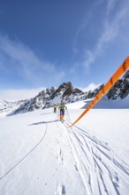 Ski tourer with rope, rope team on the Vadret da Porchabella glacier on the ascent to the summit of