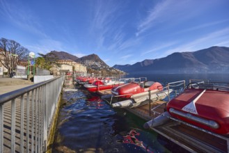 Pedal boats, metal railing, lake, shore, pavement, pedal boat rental, mountain landscape, haze,