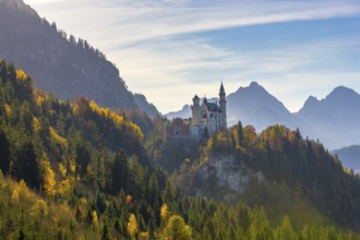 Fairytale castle on a hill surrounded by colourful autumn forests and mountains, Neuschwanstein,