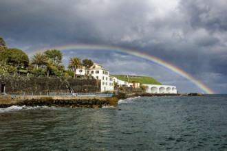 Promenade in rainy weather with rainbow on the beach of the Atlantic Ocean, municipality of Santa