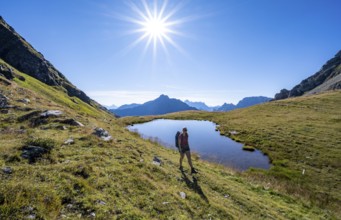 Hiker on the Carnic High Trail, small mountain lake, Carnic Main Ridge, Carnic Alps, Carinthia,