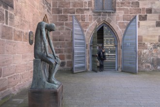 Main entrance of St Clare's Church, on the left the bronze sculpture of Job, created by the German
