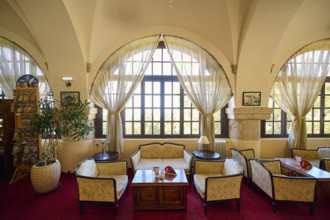 Cosy interior with large windows, curtains, seating areas and warm lighting, Elafos Hotel, Profitis