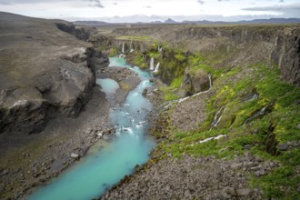 Waterfalls and a turquoise blue river flowing through a canyon, Sigöldugljúfur, long exposure,