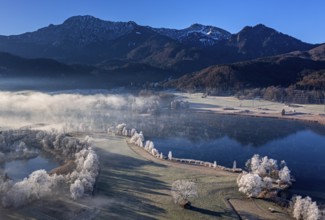 Aerial view of a lake in front of mountains in winter, hoarfrost, morning light, view of