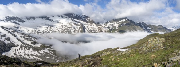 Mountaineer on a hiking trail with high fog in the valley, summit Hochfeiler, Hoher Weißzint and