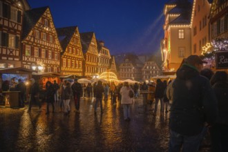 Festive hustle and bustle at the Christmas market in the old town centre under glowing lights at