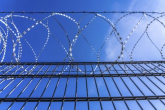 Symbolic image security, S-wire rolls, NATO wire, on a fence top, demarcation of a property,