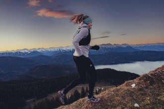 Trail running in autumn on the Jochberg on Lake Walchensee against the wonderful backdrop of the