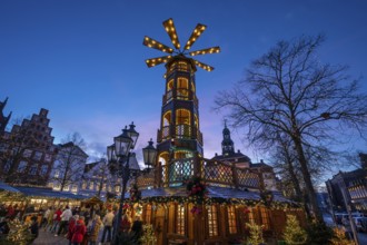 Christmas market with large Christmas pyramid at dusk, behind the historic town hall, Lüneburg,