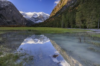 Snow-covered mountains reflected in lake, pond, autumn, Großer Ahornboden, Karwendel Mountains,