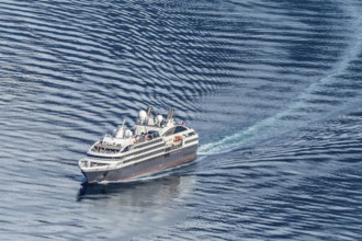 Cruise ship L'Austral leaving the Geirangerfjord into fjord Synnylvsfjord, seen from viewpoint at