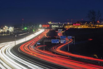 A8 motorway at Stuttgart Airport in the evening. Heavy traffic, lanes of light. Modern architecture