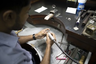 Sri Lankan man cutting a sapphire ring, gemstone cutting workshop in Kandy, Central Province, Sri