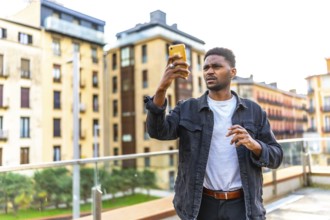 African handsome young man looking for direction using smartphone in the city