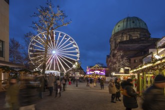 Ferris wheel at the winter village, Christmas market at dusk, St Elisabeth's Church on the right,