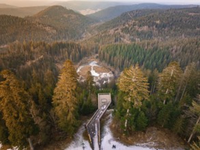 Panoramic view from the wooden walkway over snow-covered hills and forests, Ellbachseeblick viewing