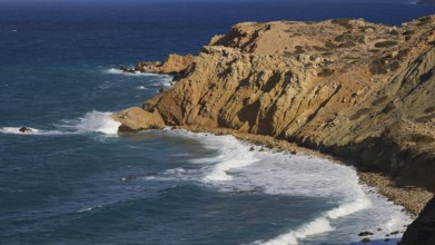 Steep cliffs with rolling waves under a clear sky, west coast, Karpathos, Dodecanese, Greek
