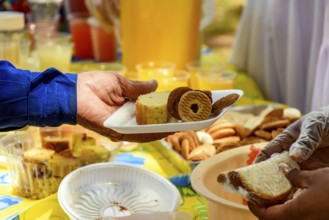 Person receiving various foods in a tray at a community breakfast Belo Horizonte, Minas Gerias,
