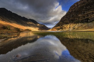 Mountains reflected in lake, evening light, cloudy mood, autumn, Loch Achtriochtan, Glencoe,